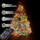 Decorated Christmas tree with colorful lights and a remote control on a dark background