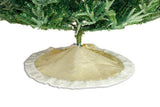 Beige Christmas tree skirt with white trim on a green Christmas tree.