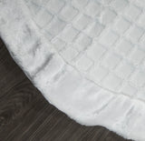 Close-up of a textured white fabric on a wooden surface