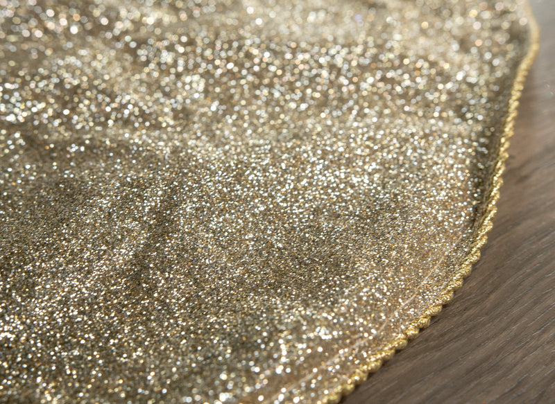 Close-up of a glittery gold fabric on a wooden surface
