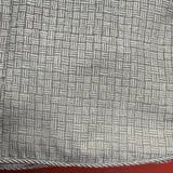 Close-up of a textured fabric with a geometric pattern on a red background