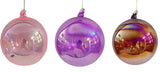 Three iridescent glass balls in pink, purple, and gold on a white background