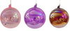 Three iridescent glass balls in pink, purple, and gold on a white background