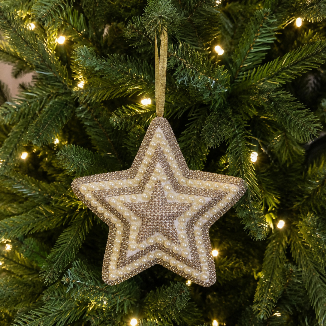 A textured, multi-layered star-shaped Christmas ornament in beige and brown tones hanging from a green Christmas tree with warm white lights.