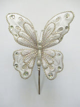 Decorative butterfly pin with intricate design on a white background
