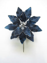 Blue flower-shaped brooch with pearl-like centers on a white background