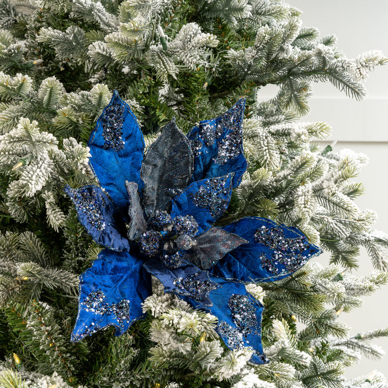 Blue glittery poinsettia decoration on a Christmas tree
