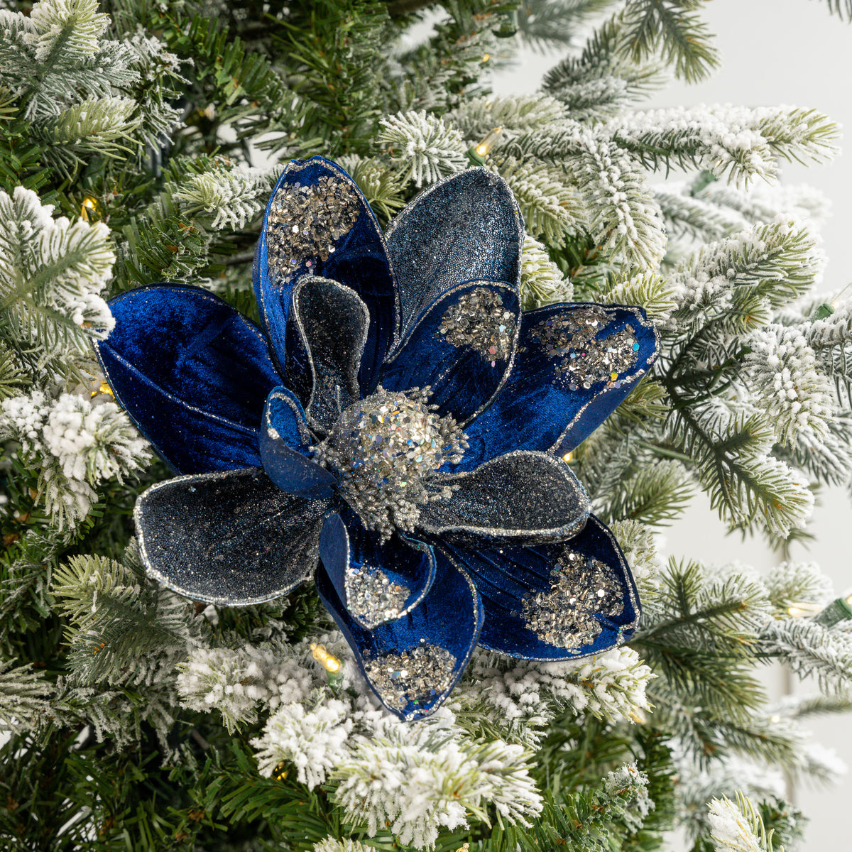 Blue floral ornament with glitter on a Christmas tree