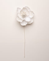 White floral hairpin on a light beige background