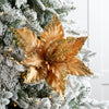 Decorative gold leaf ornament on a Christmas tree with snow effects