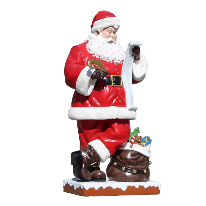 Statue of Santa Claus holding a bird against a brick wall.