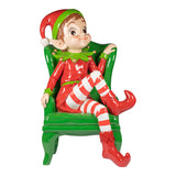 Elf figurine in a green chair on a white background