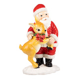 Statue of Santa Claus holding a deer with a red bow on a white background