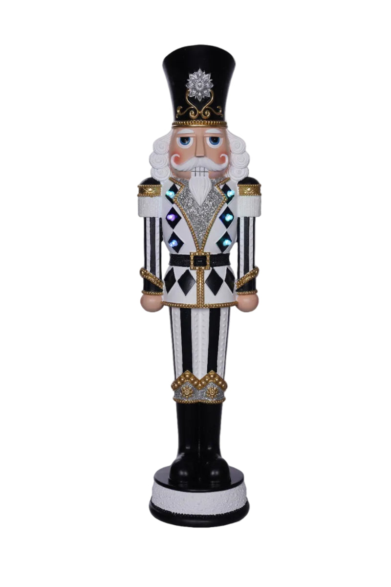 Decorative nutcracker figure with black, white, and gold details on a white background.