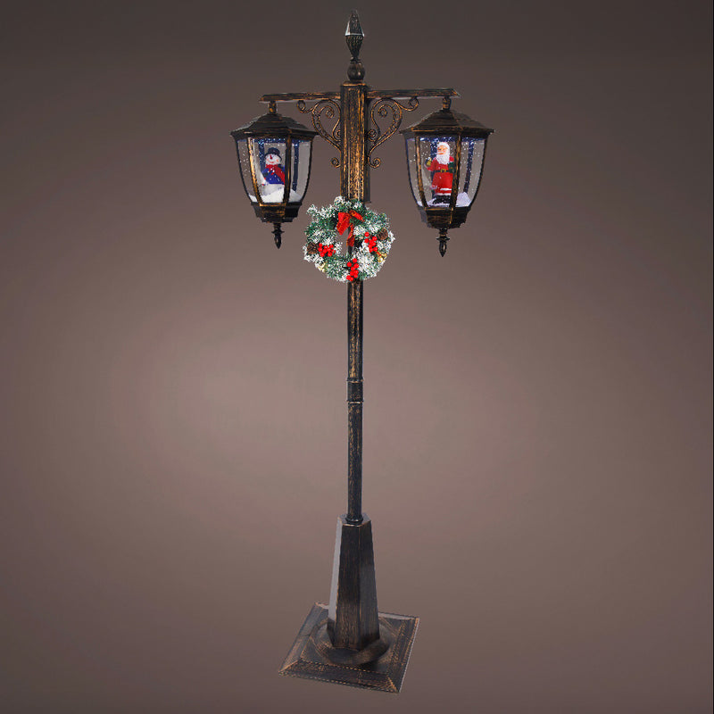 Decorative street lamp with Christmas wreath and Santa Claus figures on a brown background