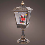 Decorative Christmas lantern with Santa Claus figure inside on a dark background