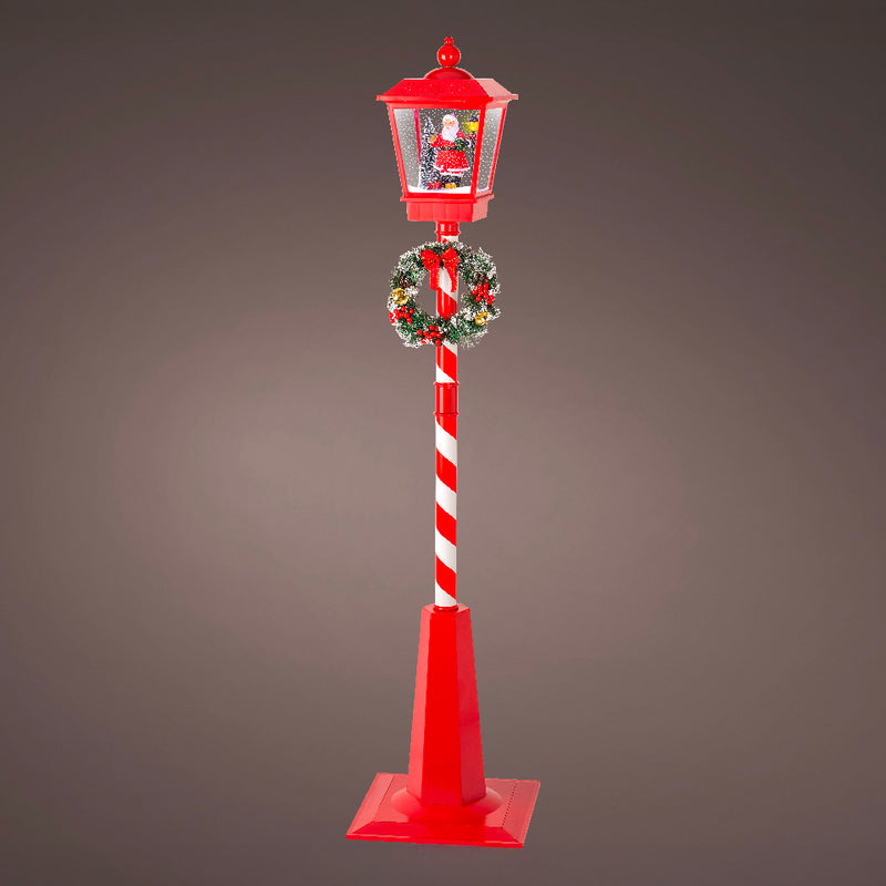 Decorative Christmas street lamp with candy cane design and wreath on a gray background