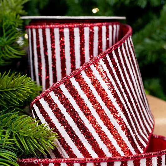 Red and white striped ribbon with glitter on a Christmas tree background