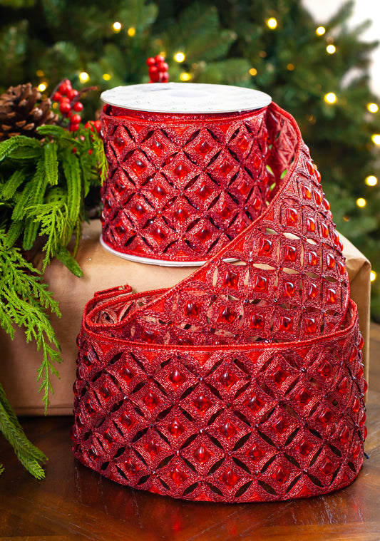 Red glittery ribbon with a woven pattern on a wooden surface, Christmas decorations in the background.
