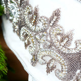 Close-up of a decorative headband with intricate beading and crystals on a blurred background.