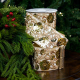 Decorative candle holder with floral patterns next to greenery