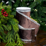 Brown high-heeled shoes with silver trim on a wooden surface with greenery and berries in the background