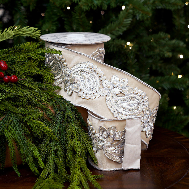 Decorative ribbon with intricate silver patterns on a green leafy background