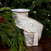 Decorative ribbon with intricate silver patterns on a green leafy background