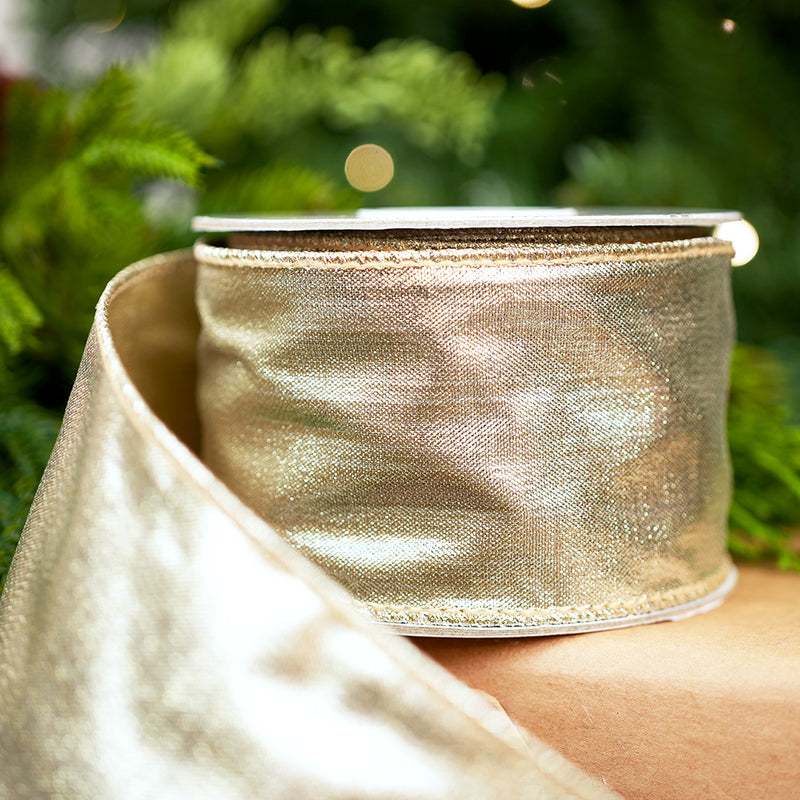 Gold metallic ribbon on a person's arm with a blurred green background
