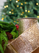 Glittery ribbon with Christmas decorations and tree in the background