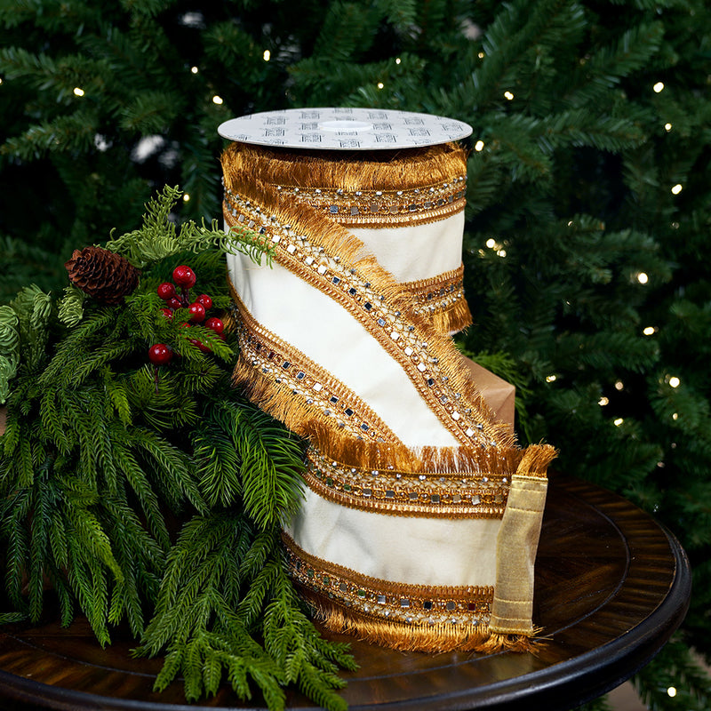 Decorative ribbon with gold and white pattern on a table with greenery and a Christmas tree in the background