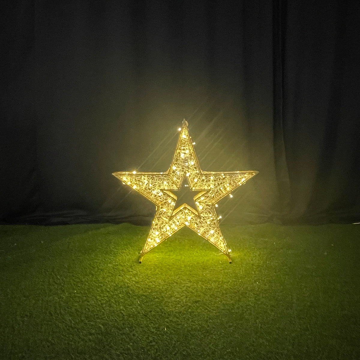 Decorative star light on a green surface with a dark background