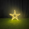 Decorative star light on a green surface with a dark background