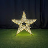 Decorative star with rhinestones on a black and green textured surface