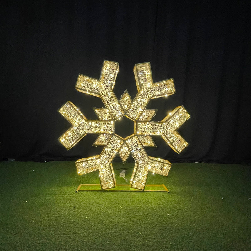 Decorative snowflake ornament with rhinestones on a green surface