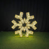 Decorative snowflake ornament with rhinestones on a green surface