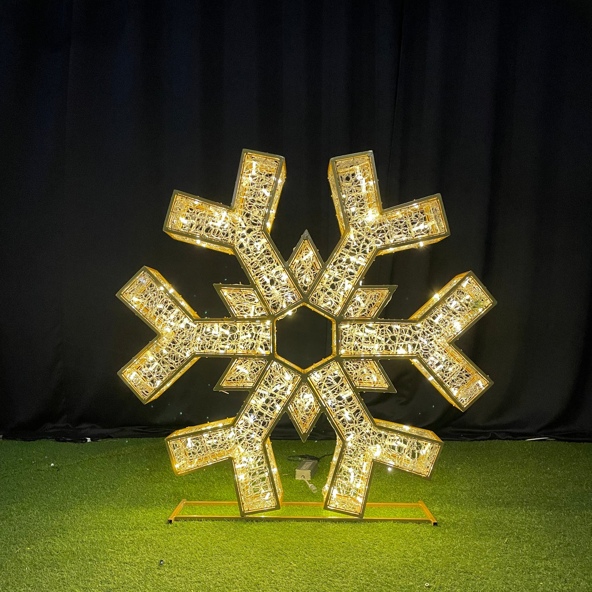 Gold snowflake-shaped decorative item on a green surface