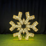 Gold snowflake-shaped decorative item on a green surface