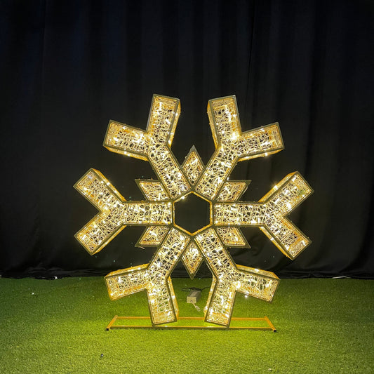Gold snowflake-shaped decorative item on a green surface