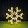 Gold snowflake-shaped decorative item on a green surface
