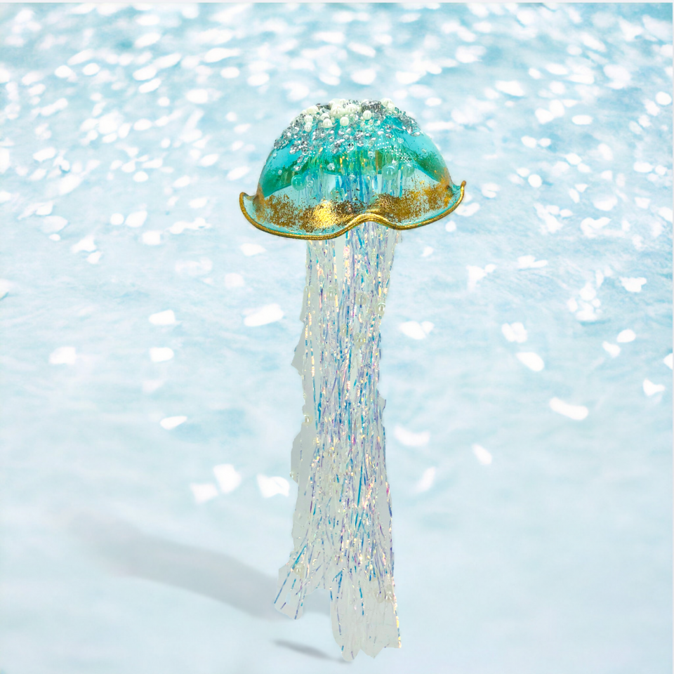 Decorative jellyfish ornament with a glittery texture on a light blue background