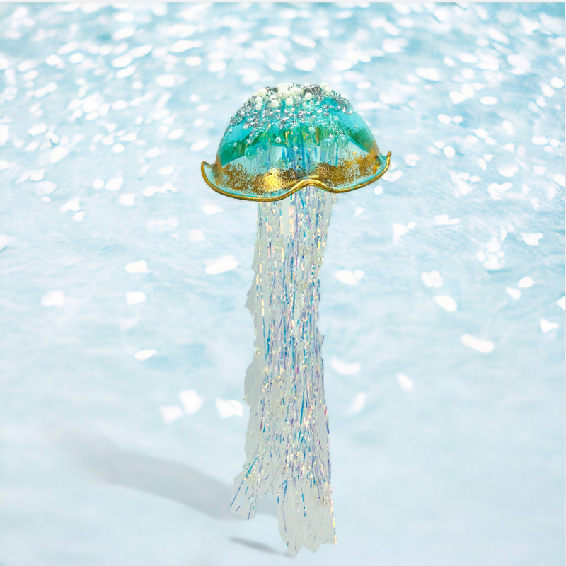 Decorative jellyfish ornament with a glittery texture on a light blue background