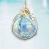 Decorative glass ornament with starfish and pearls on a light blue background
