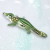 Decorative alligator ornament with beads on a glittery background