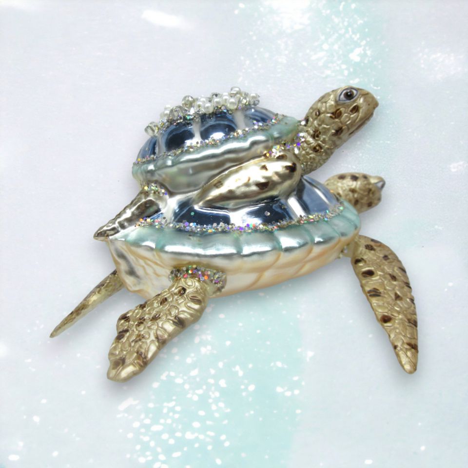 Decorative turtle figurine with gemstones on a light blue background