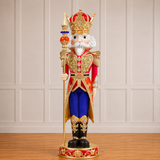 Decorative nutcracker figure with royal attire on a wooden floor.