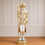 Decorative nutcracker figure with gold and white attire against a neutral wall.