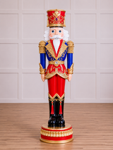 Decorative nutcracker figurine with red, blue, and gold colors on a wooden floor.