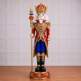 Decorative nutcracker figurine in royal attire with a crown on a wooden floor.