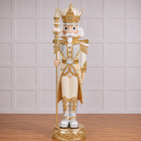 Decorative nutcracker figure with gold and white attire on a wooden surface.
